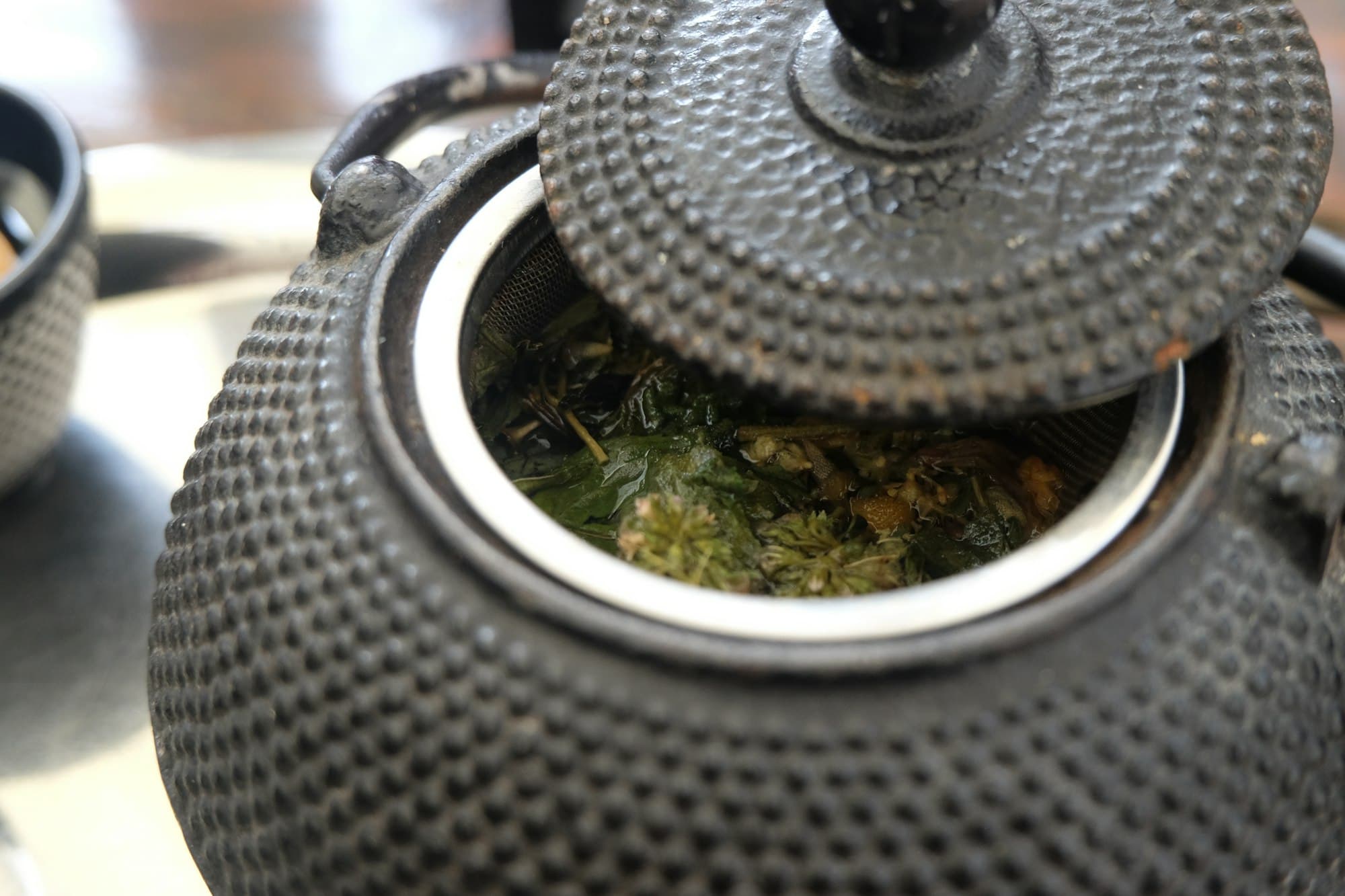 A cast iron teapot holding loose-leaf tea